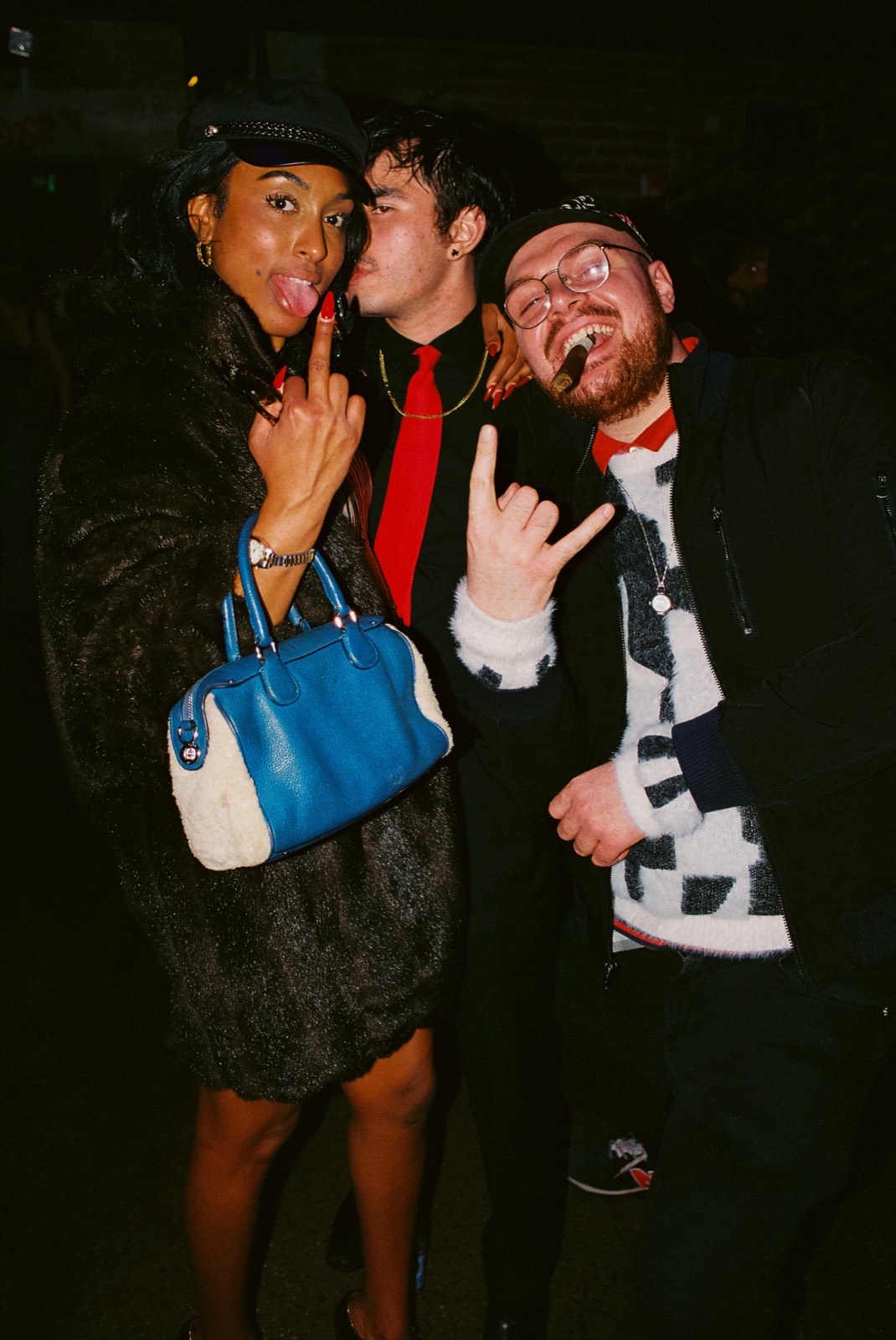Three friends striking poses together on the dance floor
